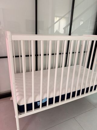 Cuna de bebé blanca con ruedas