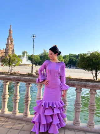 Traje de flamenca lila con mantón de flores