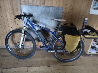 Bicicleta GT azul con alforjas