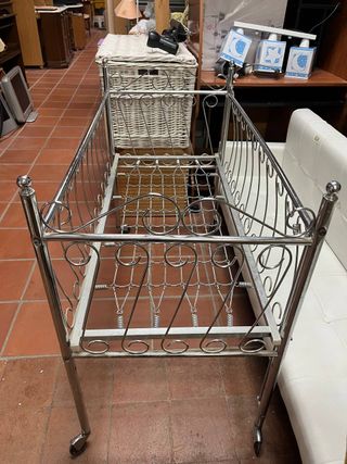 Cuna de metal antigua con ruedas