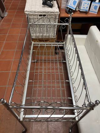 Cuna de metal antigua con ruedas