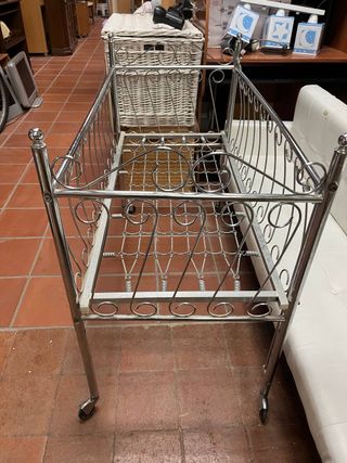Cuna de metal antigua con ruedas