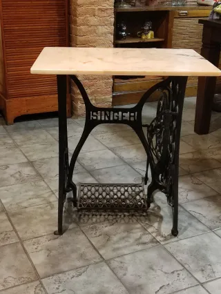 Mesa de mármol rosa con base de máquina de coser