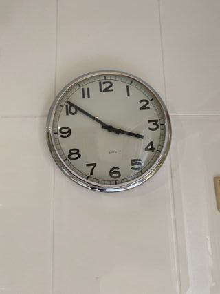 Reloj de pared plateado y blanco