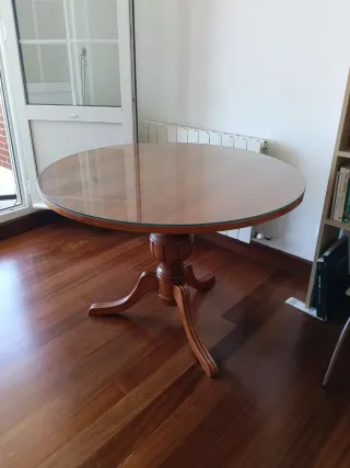 Mesa redonda de madera y cristal desmontable.