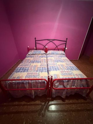 Dos camas individuales con cabecero metálico