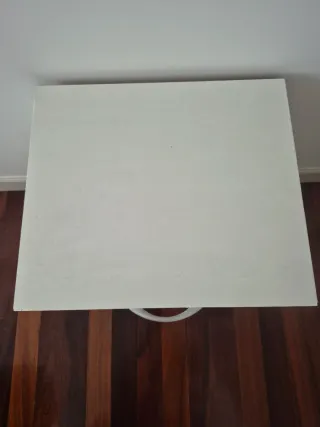 Mesita de noche de madera color blanca.