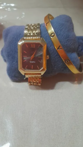 Reloj dorado de mujer y pulsera dorada.