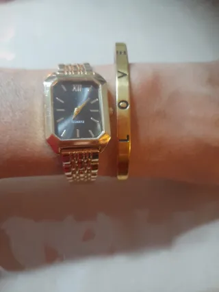 Reloj dorado de mujer y pulsera dorada.