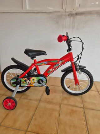 Bicicleta infantil roja con ruedas de apoyo