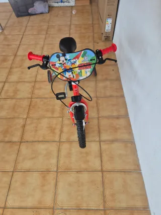 Bicicleta infantil roja con ruedas de apoyo