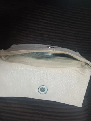 Bolso de mano beige con detalle plateado