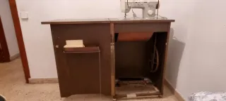 Máquina de coser antigua en su mueble de origen