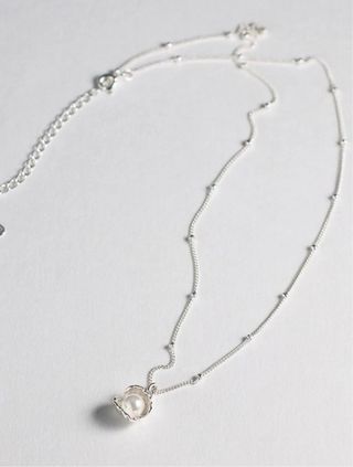 Collar de plata con diseño de concha.