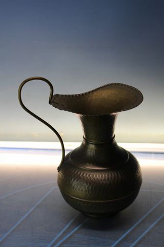 Jarra de bronce o latón martillado.