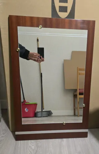 Espejo con marco de madera marrón y plata.