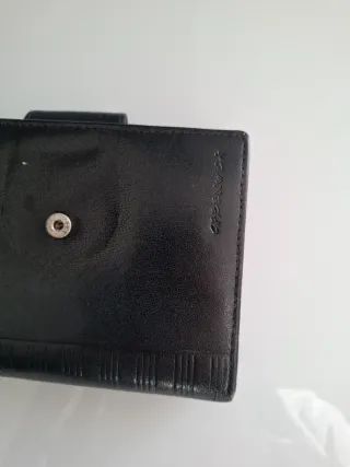 Cartera de piel negra de mujer.