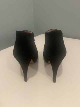 Botines de tacón negros con malla de adorno.