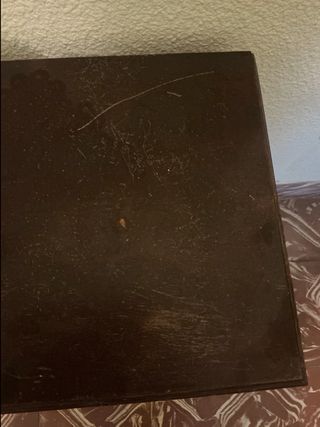 Mesita de noche de madera oscura con un cajón