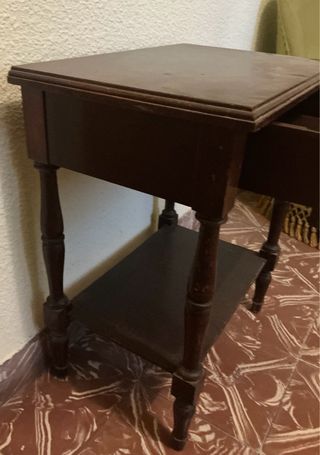 Mesita de noche de madera oscura con un cajón