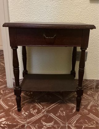 Mesita de noche de madera oscura con un cajón