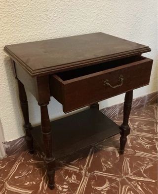 Mesita de noche de madera oscura con un cajón