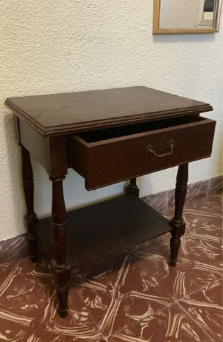 Mesita de noche de madera oscura con un cajón