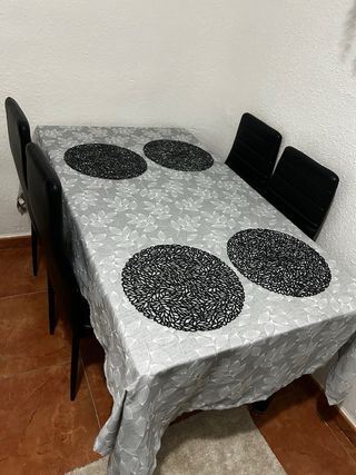 Mesa de cristal con 4 sillas negras