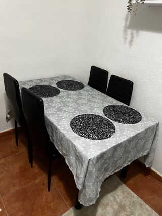 Mesa de cristal con 4 sillas negras