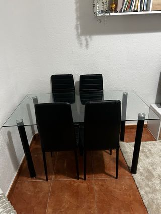 Mesa de cristal con 4 sillas negras