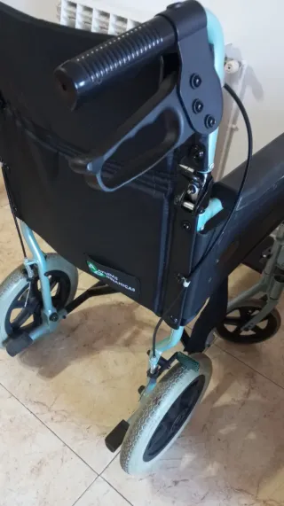 Silla de ruedas plegable azul con frenos.