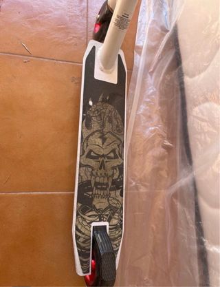 Patinete blanco y rojo con diseño calavera