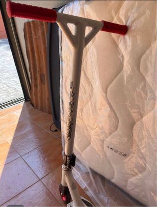 Patinete blanco y rojo con diseño calavera