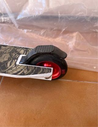 Patinete blanco y rojo con diseño calavera