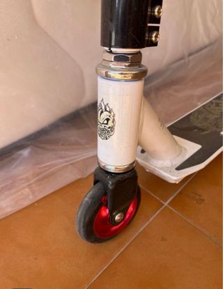 Patinete blanco y rojo con diseño calavera