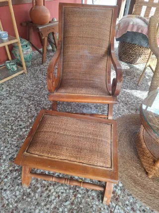 Sillón de ratán antiguo con reposapiés