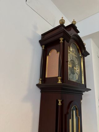 Reloj de pie clásico antiguo con péndulo y pesas.
