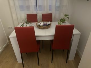 Mesa blanca con 4 sillas rojas