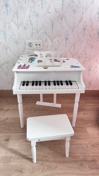 Piano infantil blanco con banqueta.