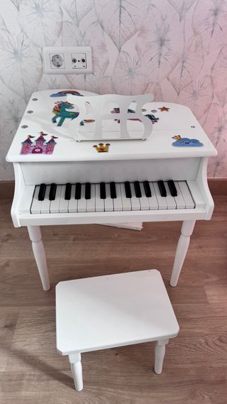 Piano infantil blanco con banqueta.