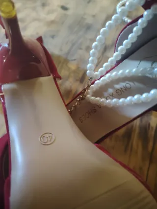 Zapatos rojos de tacón con lazo y perlas