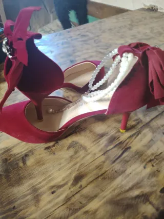 Zapatos rojos de tacón con lazo y perlas