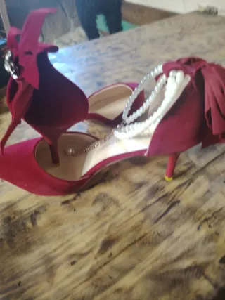 Zapatos rojos de tacón con lazo y perlas