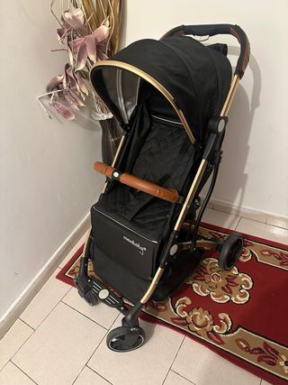 Carro de paseo plegable negro y dorado