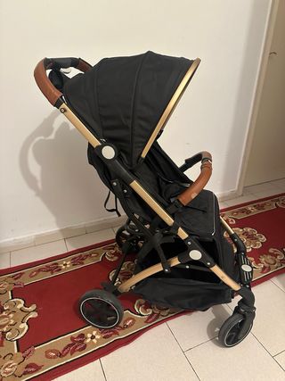 Carro de paseo plegable negro y dorado