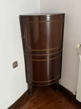 Mueble esquinero de madera oscuro.