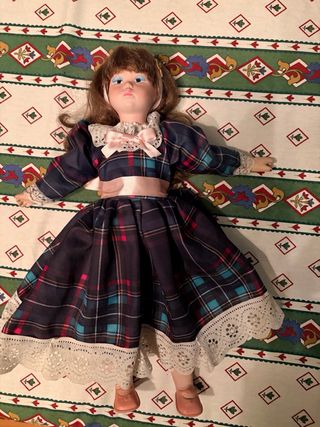 Muñeca de porcelana con vestido de cuadros