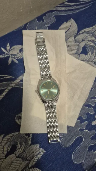 Reloj de pulsera plateado y verde
