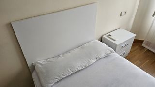 Dos camas individuales con cabecero y mesita