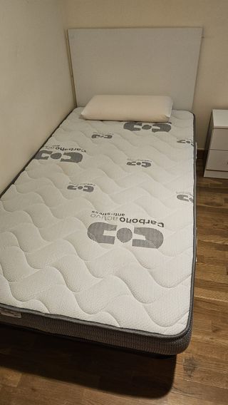 Dos camas individuales con cabecero y mesita